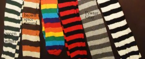 Two pairs of black and white striped stockings; a pair of red and black striped stockings; brown and light brown striped stockings; brown, tan and orange striped stockings; and rainbow striped stockings with orange, yellow, green, blue, black and red.